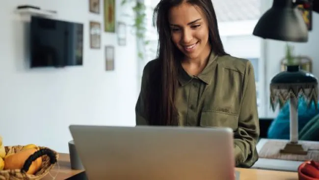 A woman facing her laptop