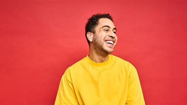 A happy man wearing a yellow shirt
