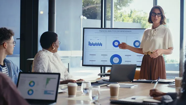team of salespeople looking at charts on computer screens