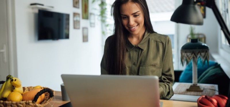 A woman facing her laptop
