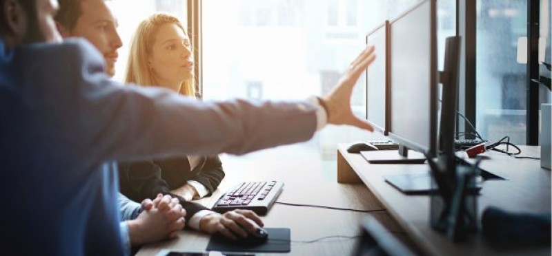 People discussing something at their workstation