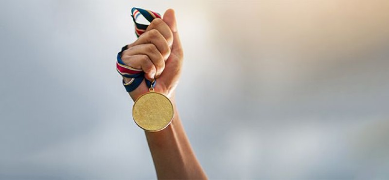Holding a gold medal
